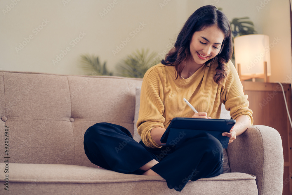 Confident pretty asian business woman working with laptop while doing some paperwork at home Confident pretty asian business woman working with laptop while doing some paperwork at home