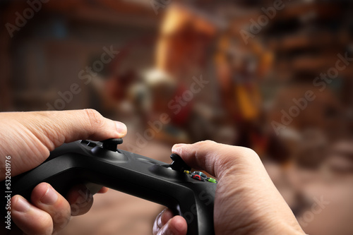 A gamer with a joystick in his hands plays a video game on the screen of a large TV. Close-up. Online games, communications, games with friends online, modern dartless technologies.