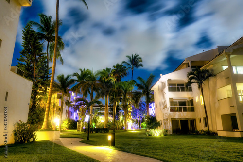 Night photo of hotel with palm trees on Mexican beaches with copyspace