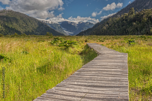 Boardwalk of the hiking path to the Michinmahuida glacier. The trail crosses the valley leading to the ice-covered towers of the volcano lying over the south part of Pumalín Park in Chilean Patagonia