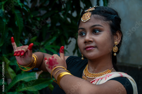 a teenage girl practicing bharatnatyam in nature photo