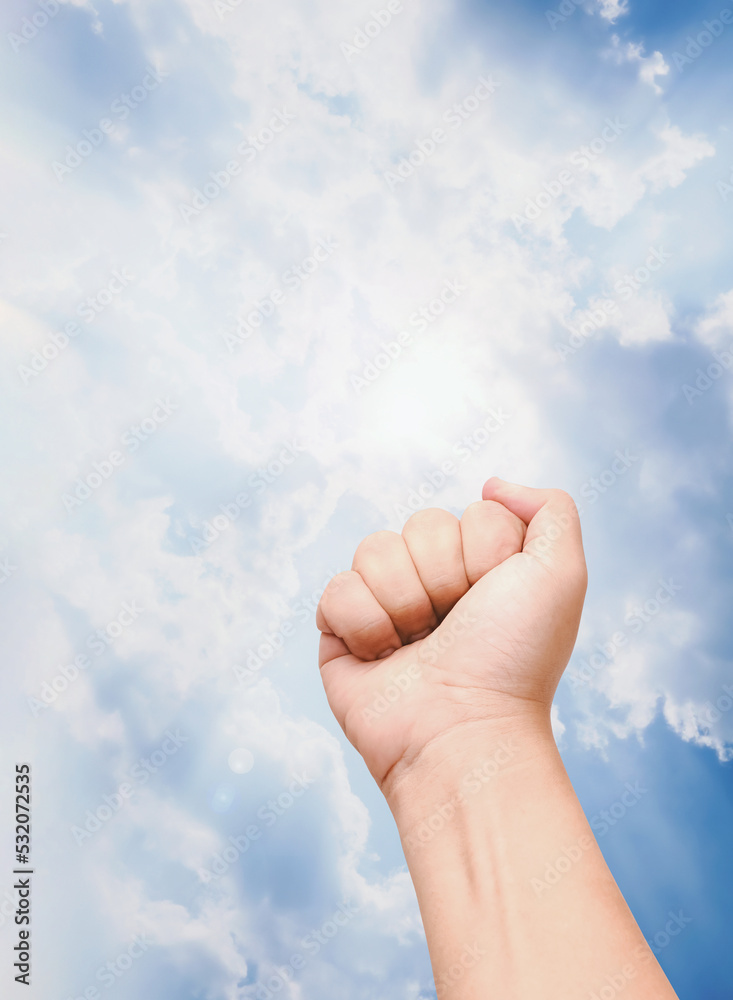 Raise fist to the sky. Looking the sunbeam shining through the clouds. Concept of hopeful and determination. Motivation for fight and never give up. Raise fist to the sky. Looking the sunbeam shining through the clouds. Concept of hopeful and determination. Motivation for fight and never give up.