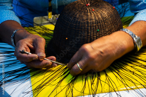Thai craftsmanship technician or professional use tools knitting and crochet woven hat sisal hemp for show and sale in studio workshop of handmade crafts market event fair in Bangkok, Thailand