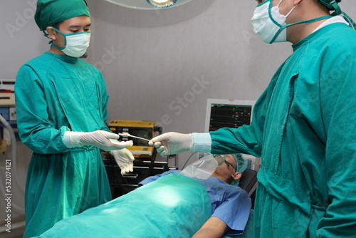 Closeup image of professional hands concentrated surgical team performing an operation with patient in hospital operating room