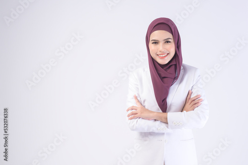 Beautiful muslim business woman wearing white suit with hijab in studio.