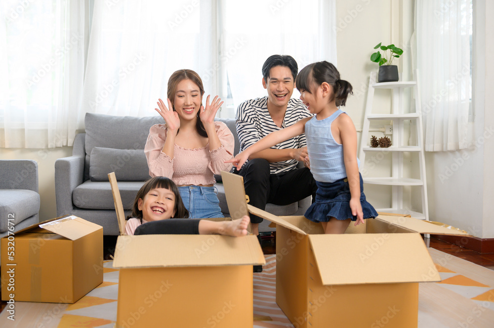 Asian family husband and wife and children with cardboard boxes having fun on moving day, Mortgage, loan, property and insurance concept. Asian family husband and wife and children with cardboard boxes having fun on moving day, Mortgage, loan, property and insurance concept.