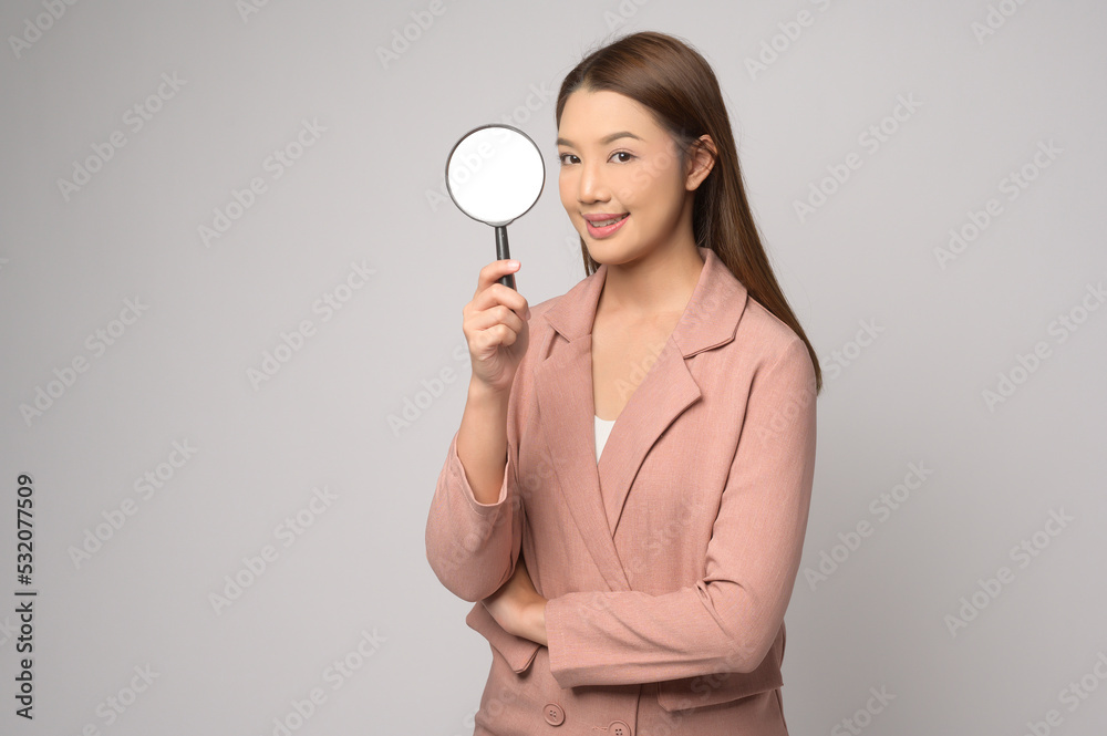 Young asian woman holding magnifying glass over white background, analysis and finance concept. . Young asian woman holding magnifying glass over white background, analysis and finance concept. .