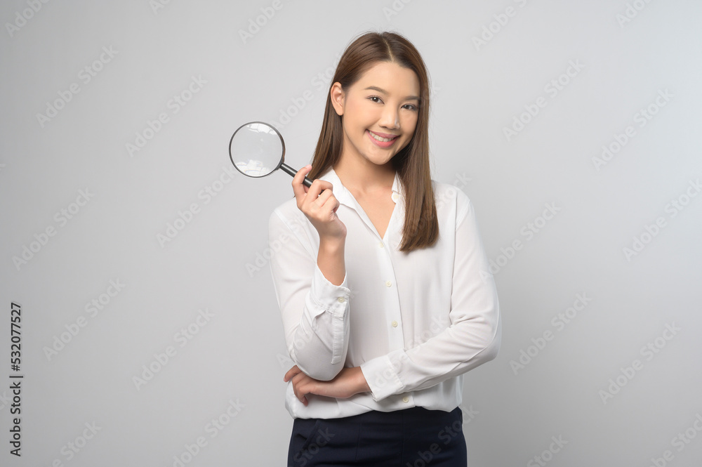 Young asian woman holding magnifying glass over white background, analysis and finance concept. . Young asian woman holding magnifying glass over white background, analysis and finance concept. .
