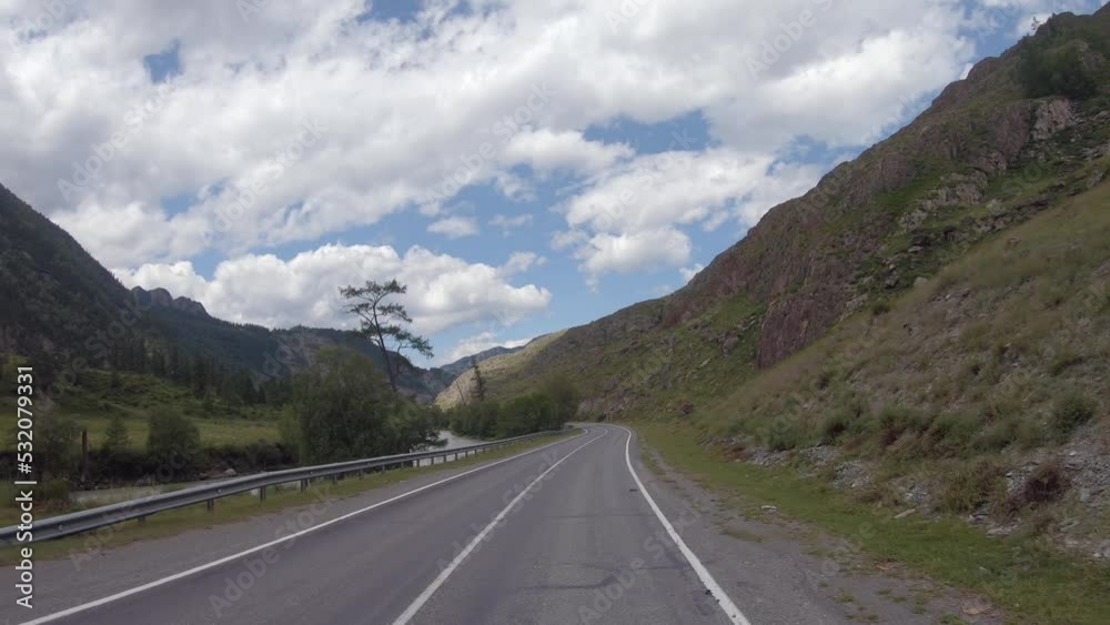Driving in a car along the mountain road of the Chuya Highway or the Chuysky Trakt in Altai. Siberia, Russia Driving in a car along the mountain road of the Chuya Highway or the Chuysky Trakt in Altai. Siberia, Russia