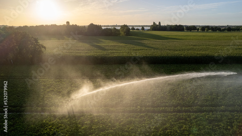 Aerial view by a drone of a agriculture field being irrigated by a gigantic and powerful irrigation system. High quality photo