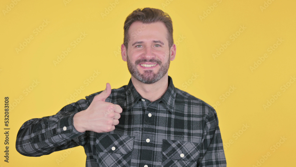 Middle Aged Man showing Thumbs Up Sign, Yellow Background