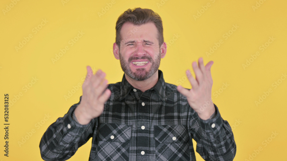 Disappointed Middle Aged Man Reacting to Loss, Yellow Background Disappointed Middle Aged Man Reacting to Loss, Yellow Background