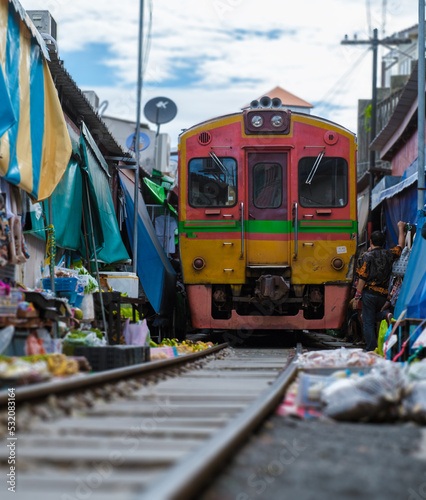 Maeklong Railway Market Thailand, . Train on Tracks Moving Slow. Umbrella Fresh Market on the Railroad Track, Mae Klong Train Station, Bangkok, Thailand on a Sunny Day photo