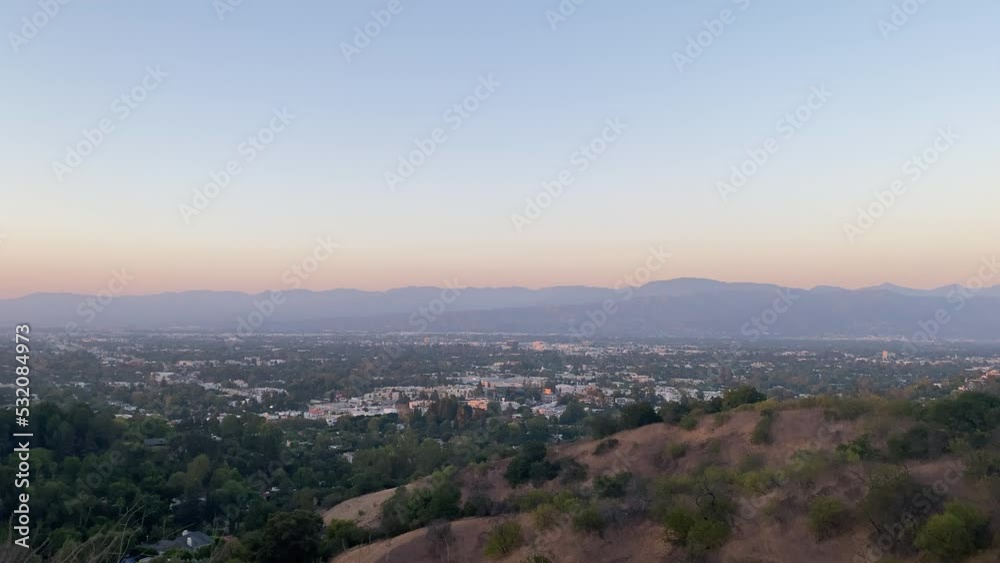 The Beginning Of Sunset Over Distant City In Los Angeles with Rolling Hills In The Background, California - wide The Beginning Of Sunset Over Distant City In Los Angeles with Rolling Hills In The Background, California - wide