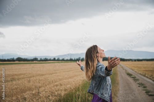 Foto Serene young woman standing and meditating or practicing breathwork on a country