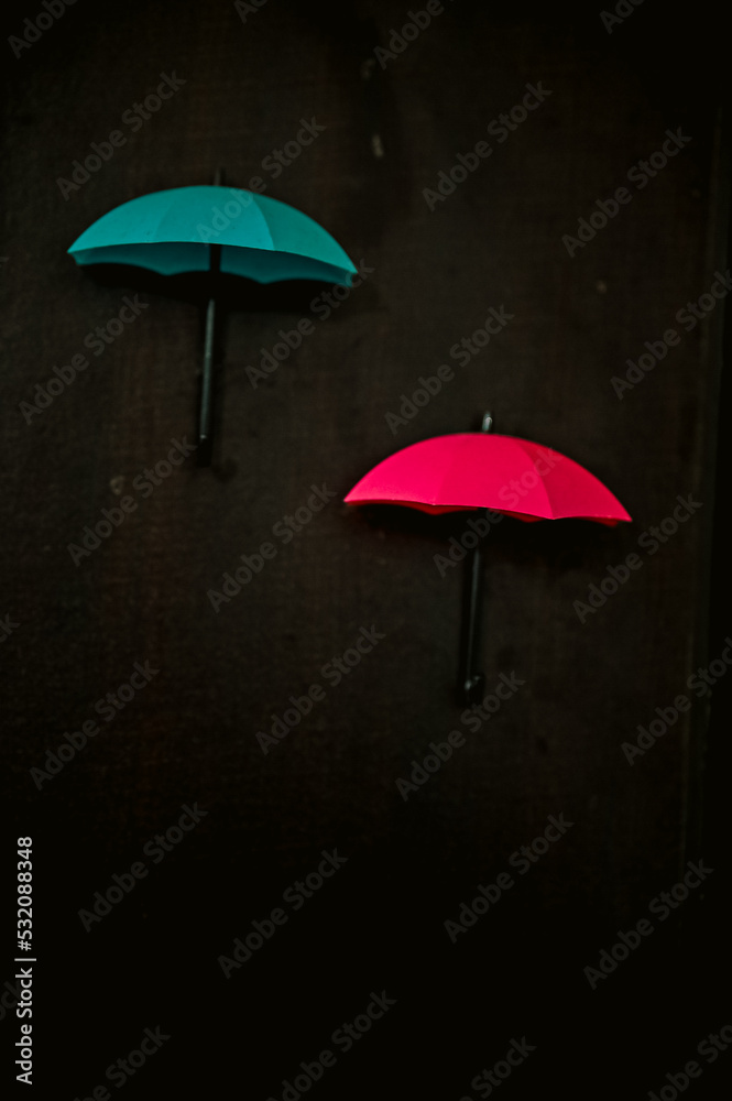 umbrella and rain. Lovely Small red and blue umbrella. Blue and Red Umbrella on wooden background.