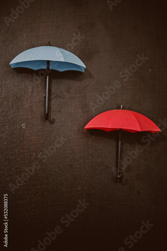 red blue umbrella under rain. Blue and Red Umbrella on wooden background. © Viktoriya Dixit