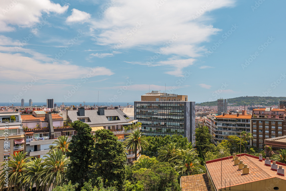 View from a rooftop to the sea and Barcelona city with modern and old buildings.