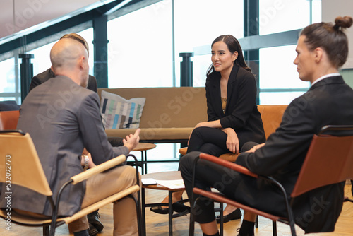 Collaborative process of multiethnic business people team working together discussing, researching, brainstorming and planning work at business meeting in modern office building and city background