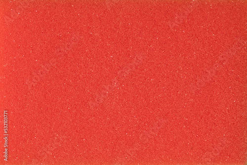 Red porous sponge with shiny details. Sponge texture. Soft porous texture.