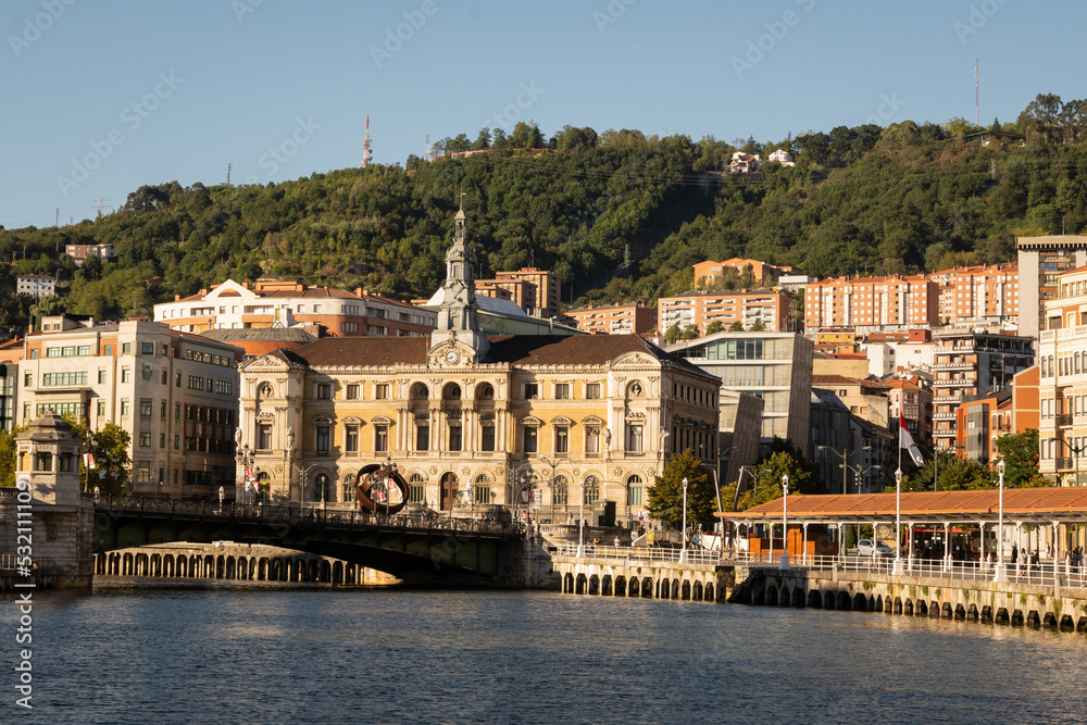 A view of the town hall in Bilbao and the bridge Puente del Ayuntamiento crossing over the estuary river nervion