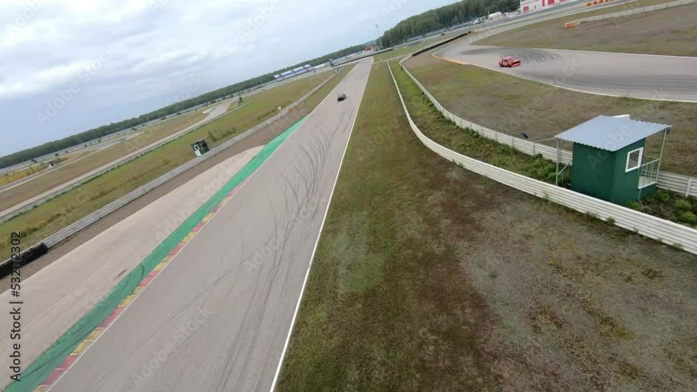aerial filming of a circuit race on an asphalt circuit, fpv drone, racing cars go fast, time trials, sharp turns aerial filming of a circuit race on an asphalt circuit, fpv drone, racing cars go fast, time trials, sharp turns