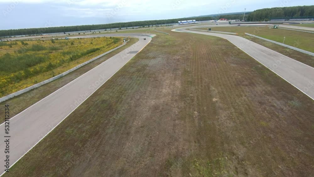 aerial filming of a circuit race on an asphalt circuit, fpv drone, racing cars go fast, time trials, sharp turns aerial filming of a circuit race on an asphalt circuit, fpv drone, racing cars go fast, time trials, sharp turns