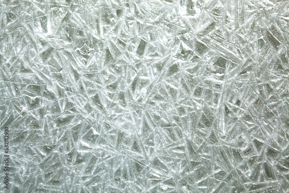 The texture of the ice surface. Winter background, festive background in the form of ice crystals, ice background for New Year's card. The texture of the ice surface. Winter background, festive background in the form of ice crystals, ice background for New Year's card.