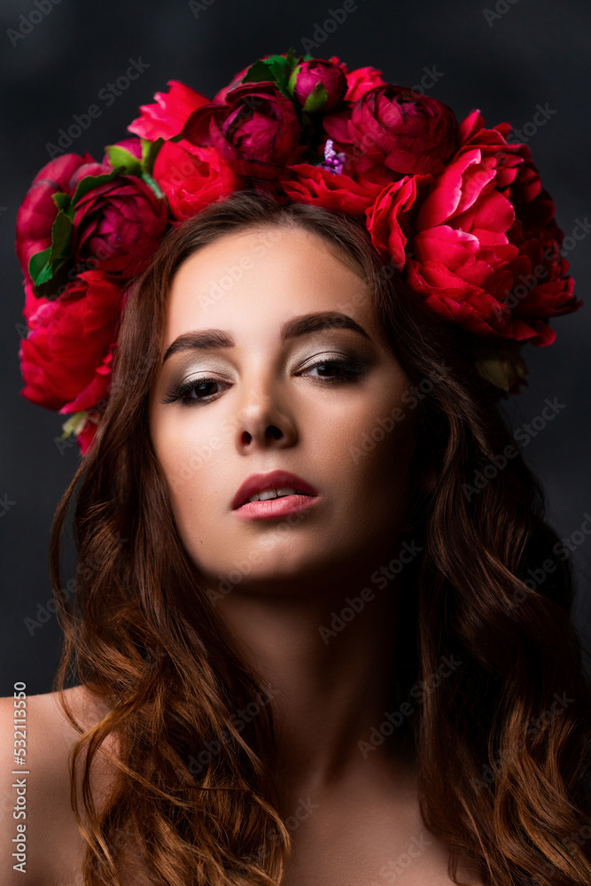Beautiful Ukrainian woman in a colorful wreath of pink and burgundy peony. Girl's headdress. Sensual portrait