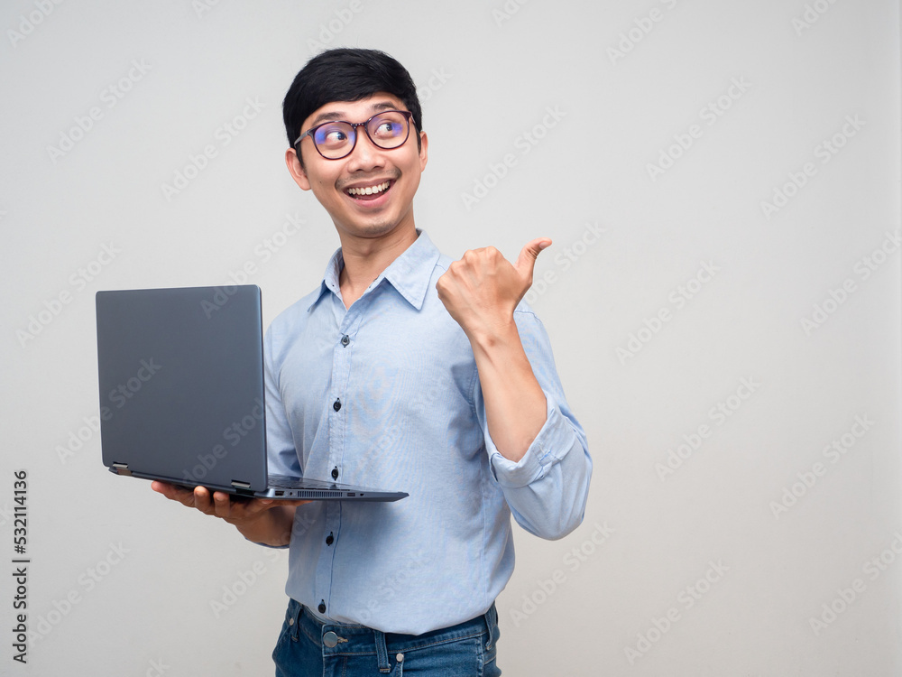 Cheerful businessman hold laptop smile point finger at copy space Cheerful businessman hold laptop smile point finger at copy space