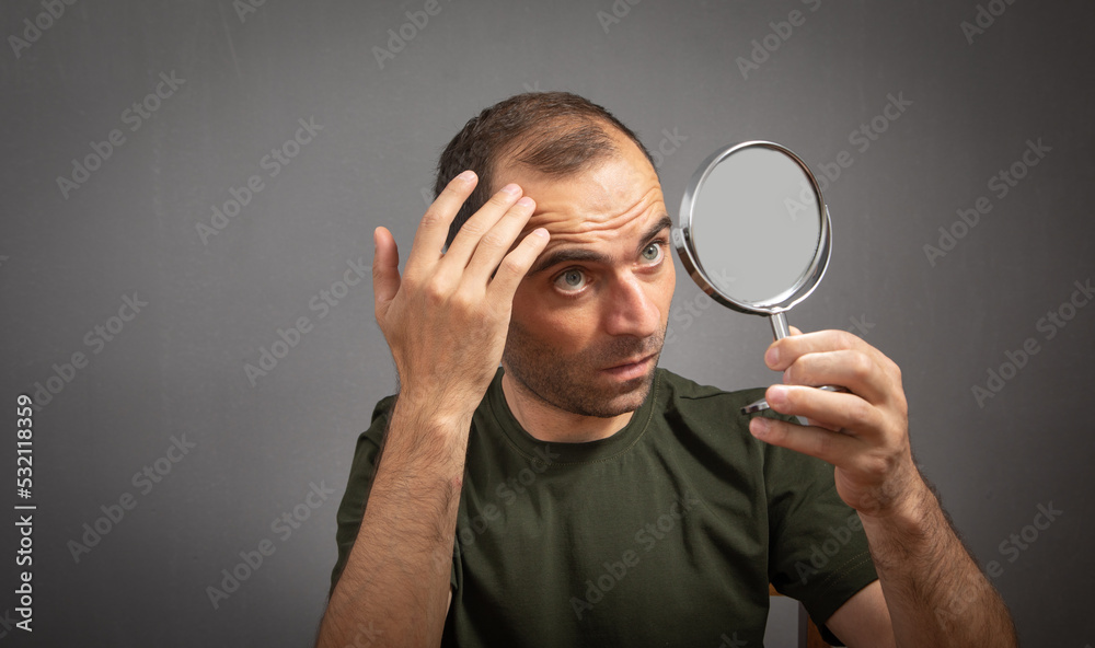 Man looking at mirror. Hair loss concept Man looking at mirror. Hair loss concept