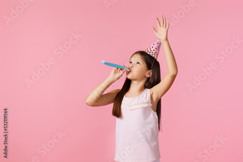 Photography happy little birthday girl with party cone hat and whistle