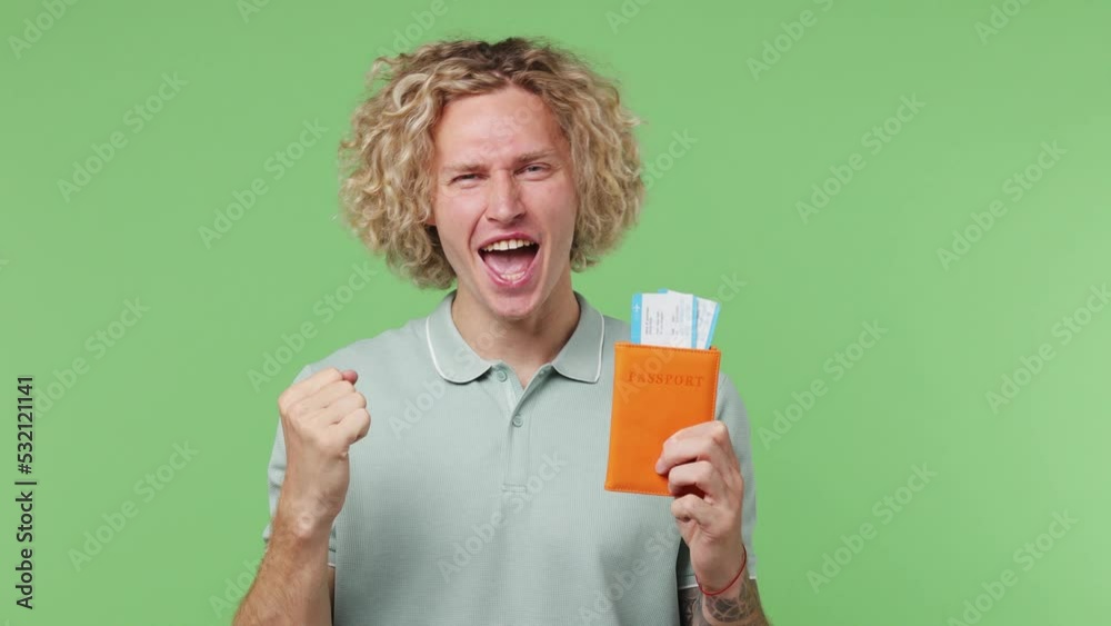 Traveler happy man wear shirt hold passport boarding tickets do winner gesture isolated on plain pastel light green background. Tourist travel abroad to rest getaway. Air flight trip journey concept Traveler happy man wear shirt hold passport boarding tickets do winner gesture isolated on plain pastel light green background. Tourist travel abroad to rest getaway. Air flight trip journey concept