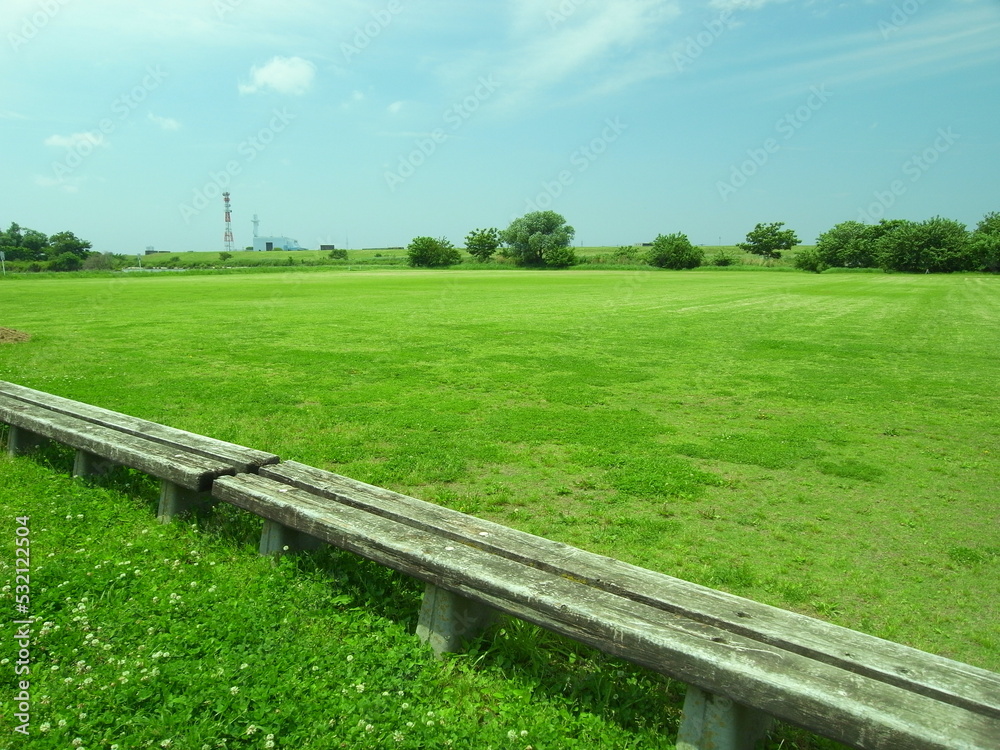 初夏の平日のベンチのある江戸川河川敷のサッカー場風景