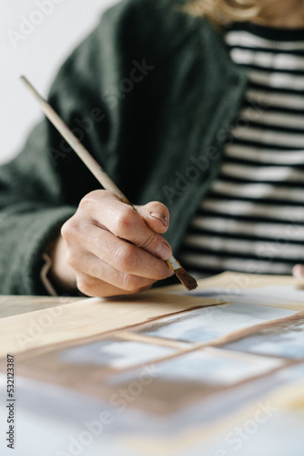 Woman paints with a brush paints on a sheet