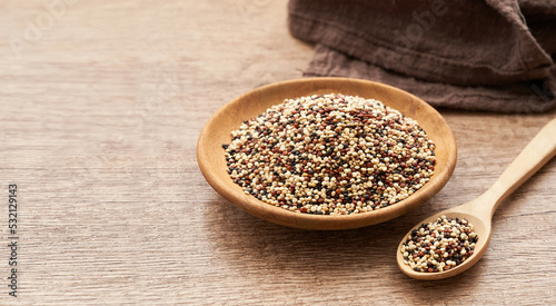 quinoa seeds in wooden spoon and plate on wood table background. quinoa seeds 