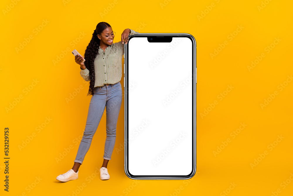 © deagreez - Full body portrait of pretty positive person look empty space huge phone isolated on yellow color background