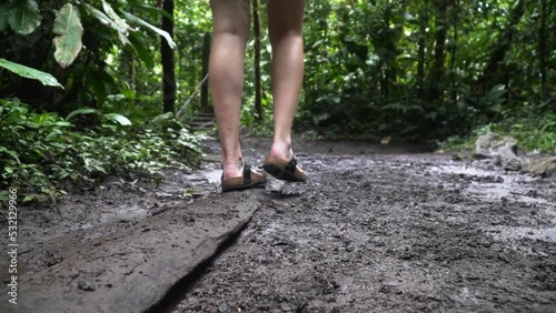 lady walks along a rotted wooden plank to avoid the mud costa rica national park