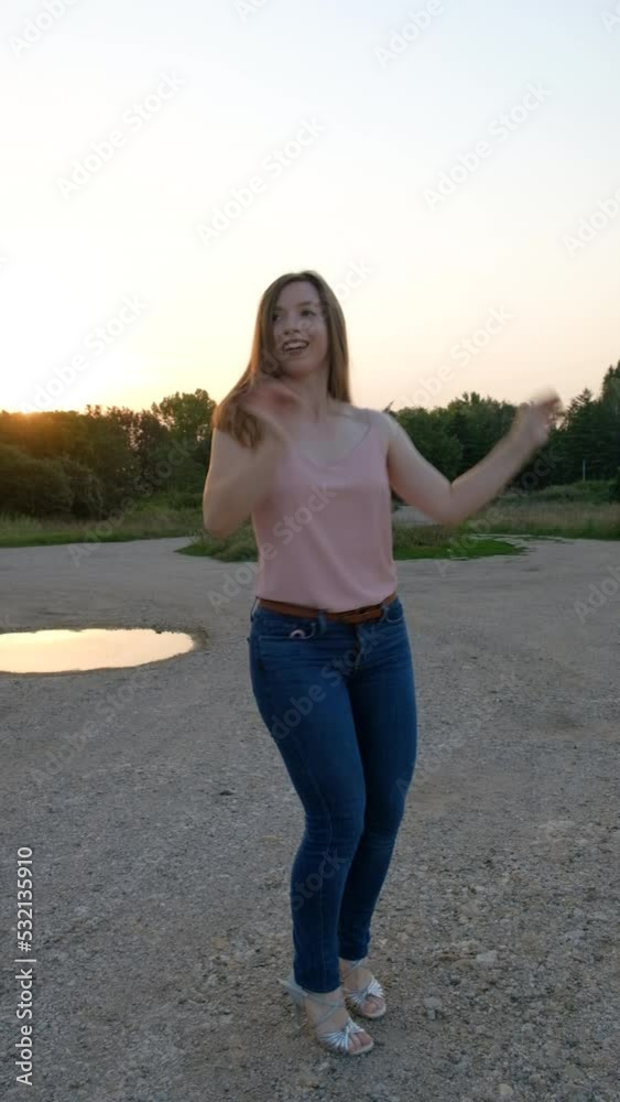 Young millennial woman dancing salsa alone with joy in nature at golden hour Young millennial woman dancing salsa alone with joy in nature at golden hour