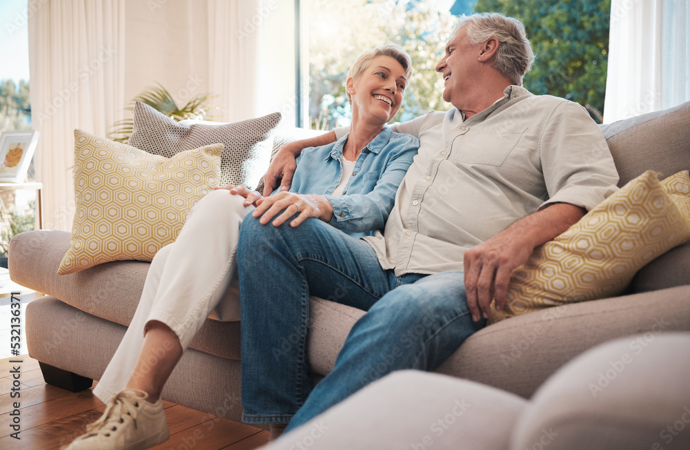 Retirement couple smile on sofa talking about happy marriage, pension and wealth in home or holiday house. Hug, love and care senior woman with man relax on couch together in living room for summer