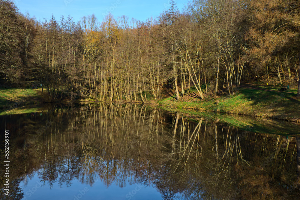 Autumn forest scenery. Reflection of trees on the lake water surface. A forest nature. Vivid October bright day in colorful forest. Autumn forest scenery. Reflection of trees on the lake water surface. A forest nature. Vivid October bright day in colorful forest.