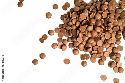 Close up of milk chocolate chips. Scattered chocolate callets isolated on white. Texture of chocolate
