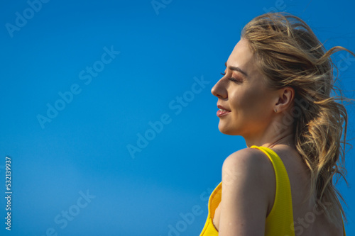 Fototapet closeup sideview of happy smiling attcative caucasian woman in yellow sundress l