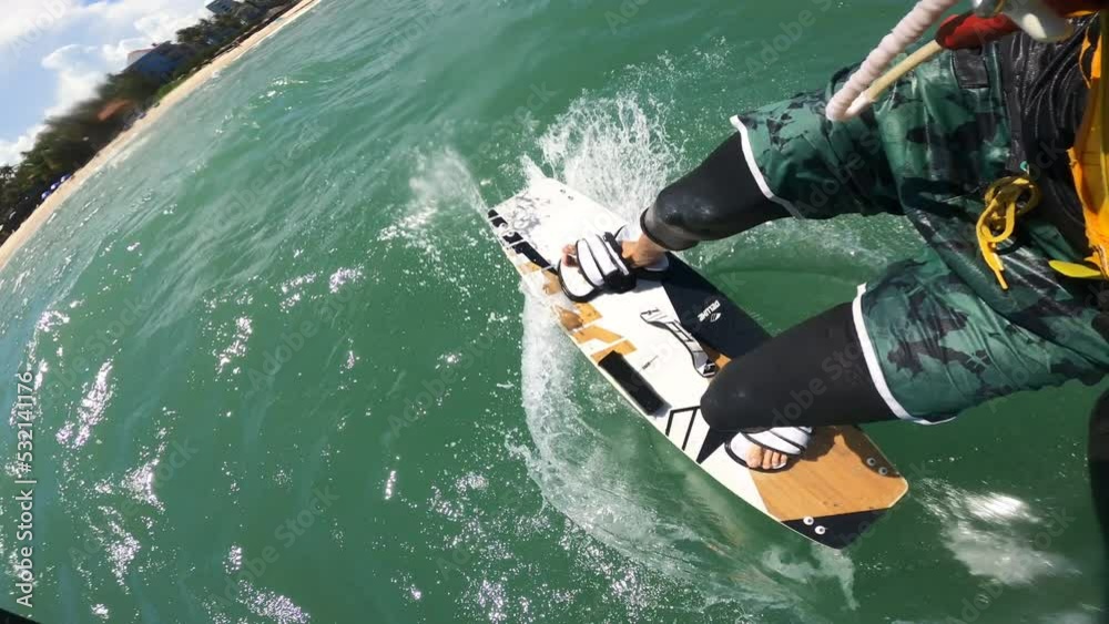 POV of a kite surfing doing acrobatic tricks on tropical ocean, vertical video