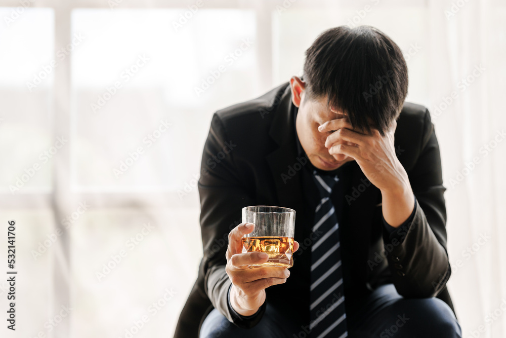 Sad depressed addicted drunk guy, Alone asian man drinker alcoholic sitting at bar counter with glass drinking whiskey. Sad depressed addicted drunk guy, Alone asian man drinker alcoholic sitting at bar counter with glass drinking whiskey.
