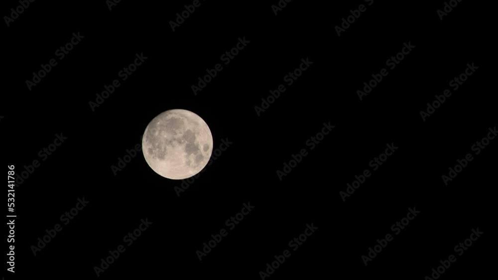 Almost full moon moves very slowly in clear black sky, copy space Almost full moon moves very slowly in clear black sky, copy space