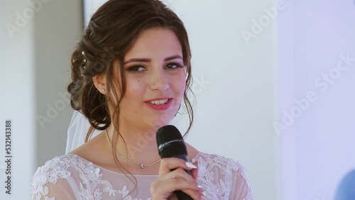 Portrait of beautiful young newlyweds talking to the microphone. Happy moment photo
