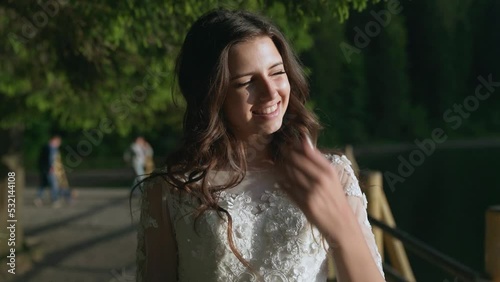 beautiful shy girl smiling, touch herself and goes to the camera on sun glares