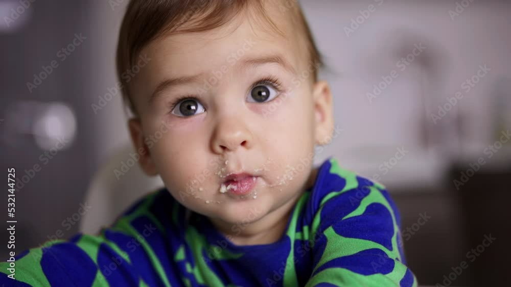 Grey-eyed lovely baby with smudged face. Close up. Little kid eating dairy. Child nutrition. Blurred backdrop. Grey-eyed lovely baby with smudged face. Close up. Little kid eating dairy. Child nutrition. Blurred backdrop.