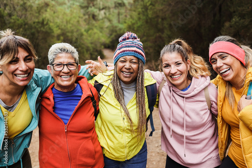 Multiracial women having fun during trekking day in mountain forest - Focus on african woman face